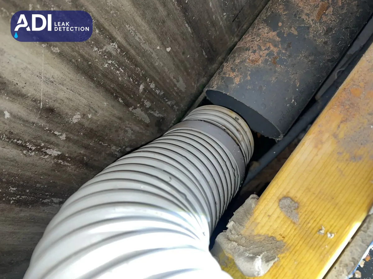 A flexible pan connector entering the soil pipe